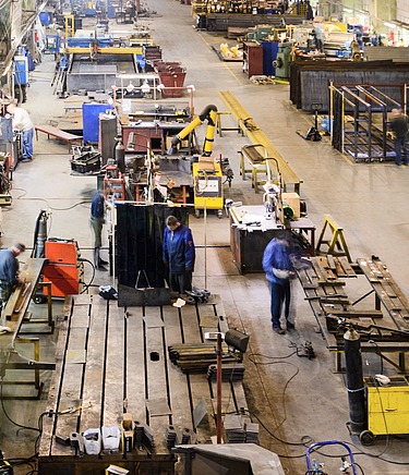 Produktionshalle mit Betonboden und industriellen Arbeitsstationen – robuste Betonfläche für schwere Maschinen und Fertigungsprozesse in der Metall- und Bauindustrie.
