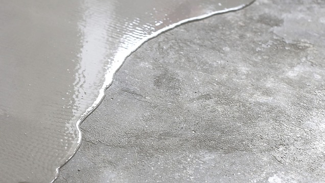 Frisch aufgetragener selbstnivellierender Estrich auf einem Betonboden für einen ebenen, belastbaren Industrieboden 