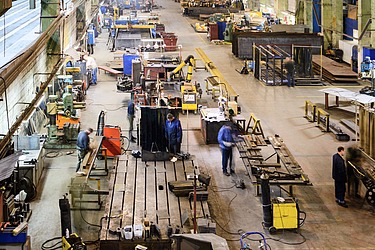 Produktionshalle mit Betonboden und industriellen Arbeitsstationen – robuste Betonfläche für schwere Maschinen und Fertigungsprozesse in der Metall- und Bauindu