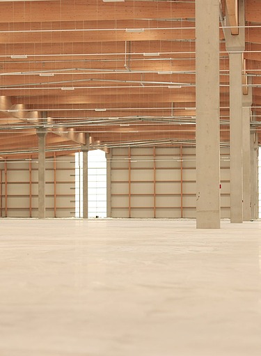 Große Industriehalle mit Betonboden. Die glatte, belastbare Betonsohle bietet eine stabile Grundlage für Produktions- und Lagerflächen und erfüllt höchste Anforderungen an Langlebigkeit