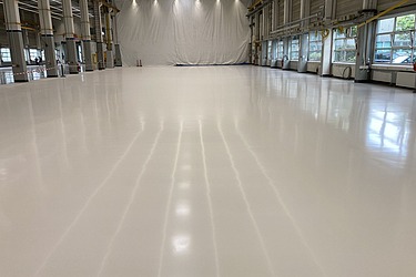 Hochwertiger Industrieboden mit Beschichtung in großer Industriehalle.