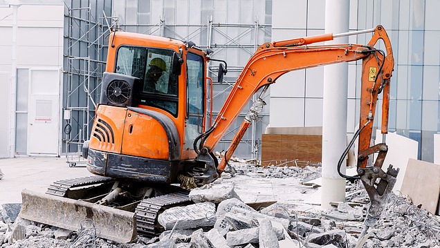 Bagger beim Abbruch eines alten Industriebodens zur vollständigen Erneuerung und Sanierung