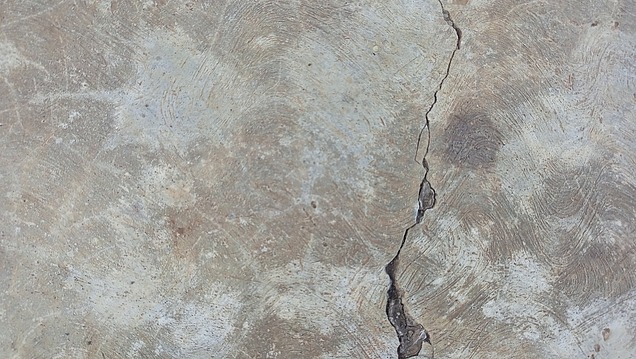 Riss in einer beschädigten Betonoberfläche als typisches Bild für Betonsanierung und Instandsetzung.